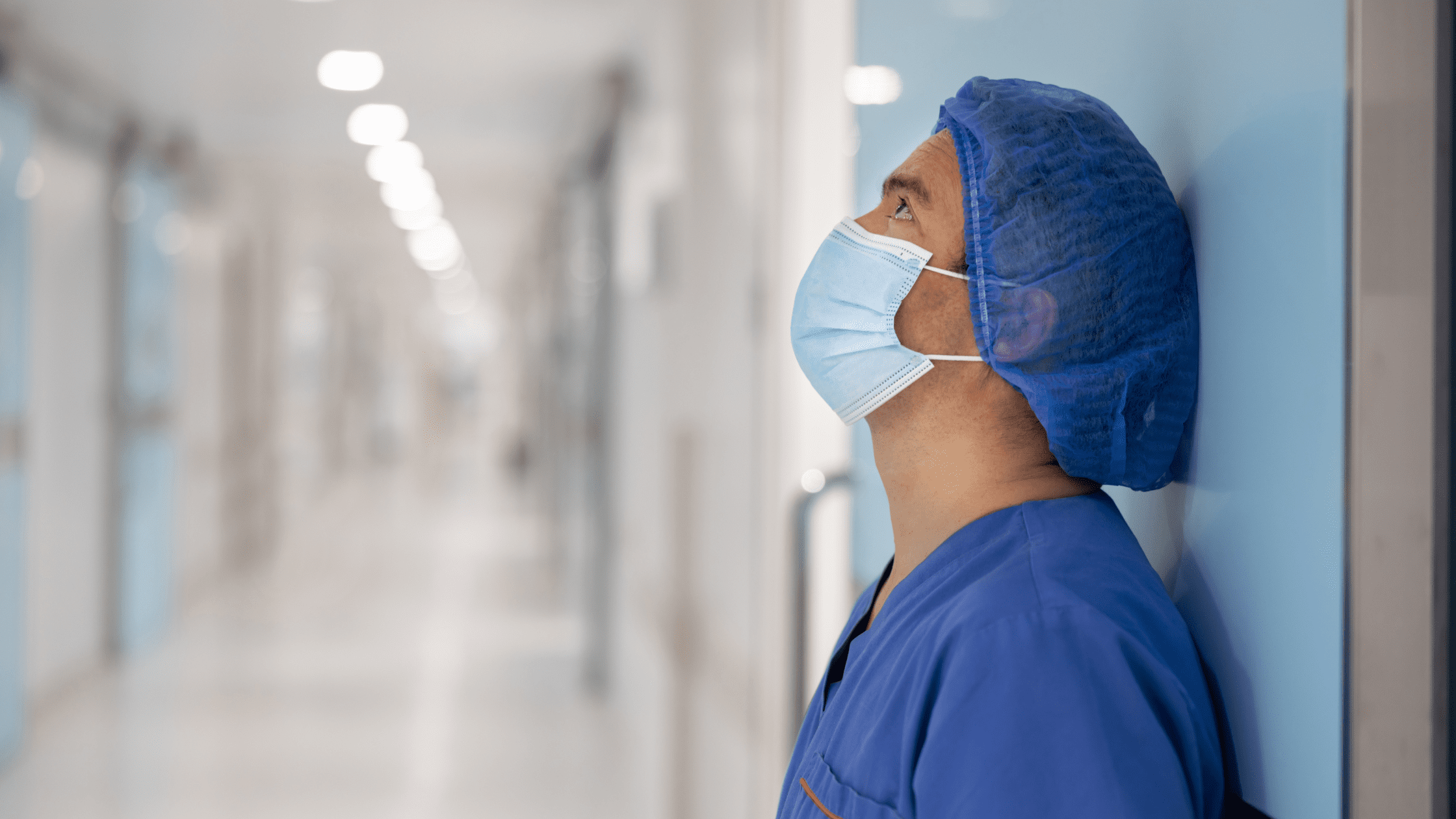 Frustrated surgeon leaning up against a wall after learning that he got a low ABSITE score.